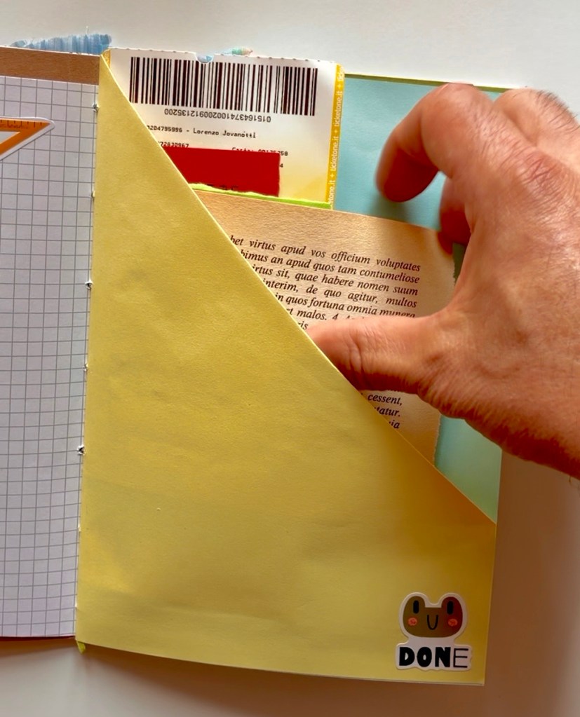 Una mano che sfoglia una pagina gialla di un quaderno, mostrando un documento con un codice a barre e un testo parzialmente visibile.