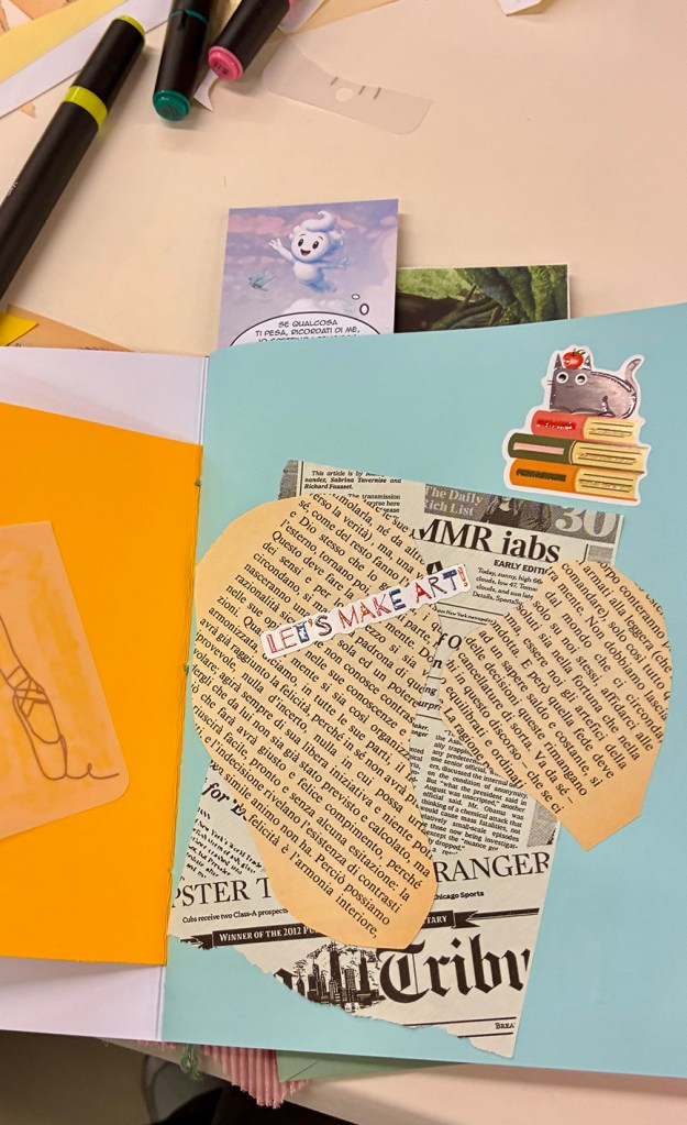 Pagina di un quaderno decorata con carta da giornale, adesivi e un messaggio 'LET'S MAKE ART!'